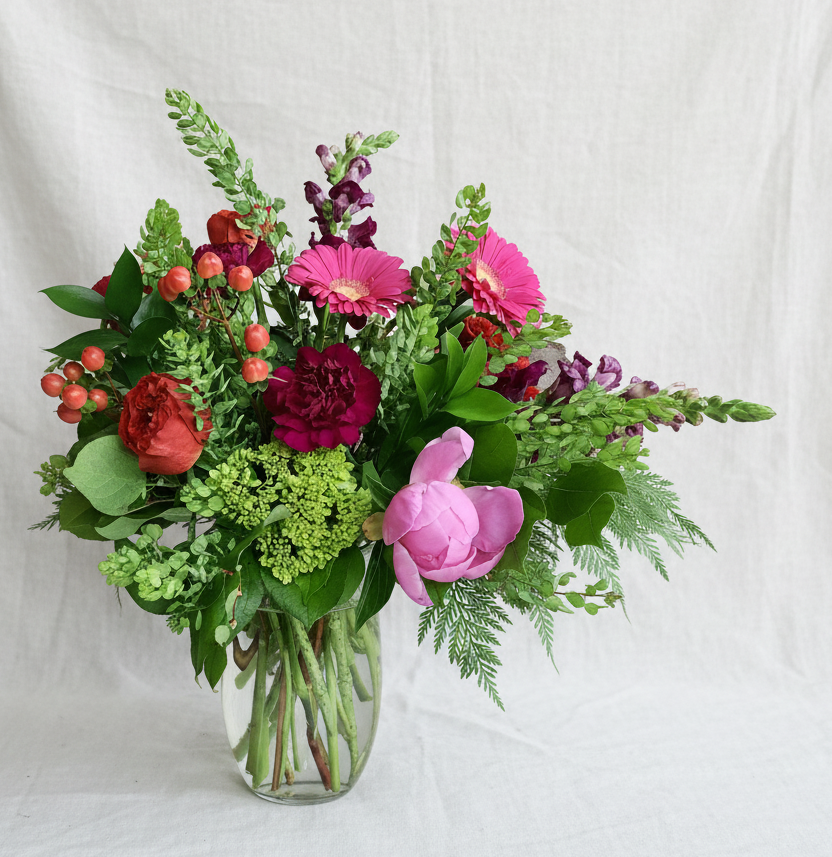 Luxury Berry Crush flower arrangement featuring plum and magenta roses in a clear glass vase